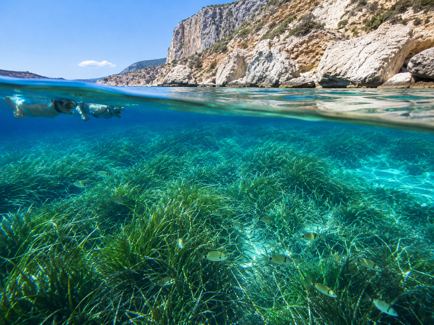 Autore in kayak all'ingresso di una grotta marina dalle acque azzurre di Karpathos