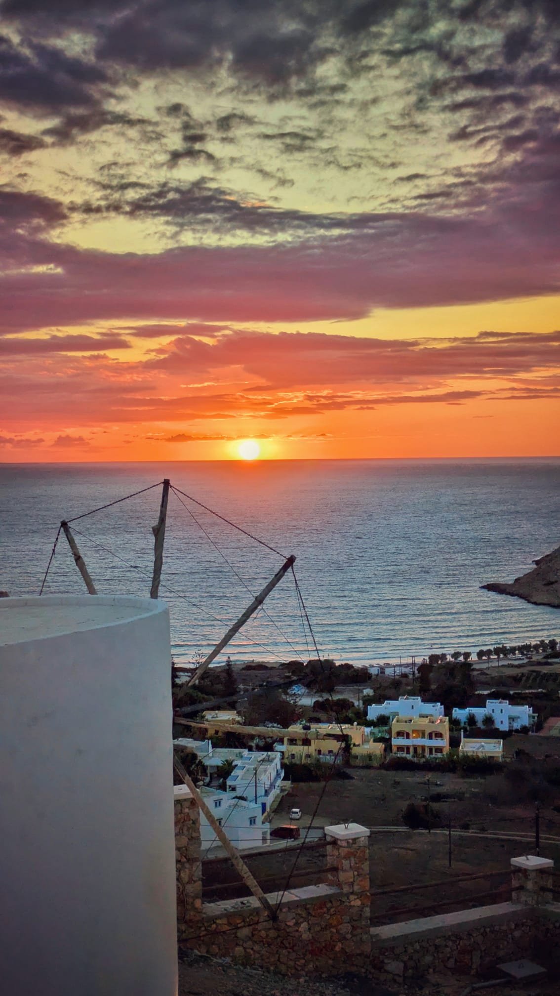 Tramonto infuocato dietro un mulino a vento tipico di Karpathos